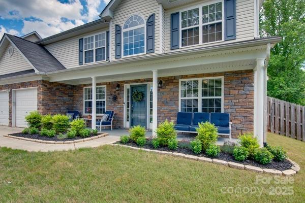 136 Elba Dr, Mooresville, NC 28115 - view of front facade featuring stone siding, a porch, a garage, and concrete driveway