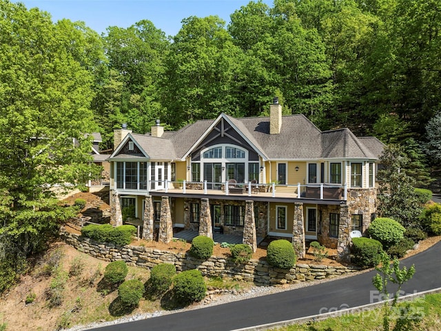 714 Wickhams Fancy Dr, Biltmore Lake, NC 28715 - view of front of house with a chimney, a patio area, a shingled roof, stone siding, and a wooden deck