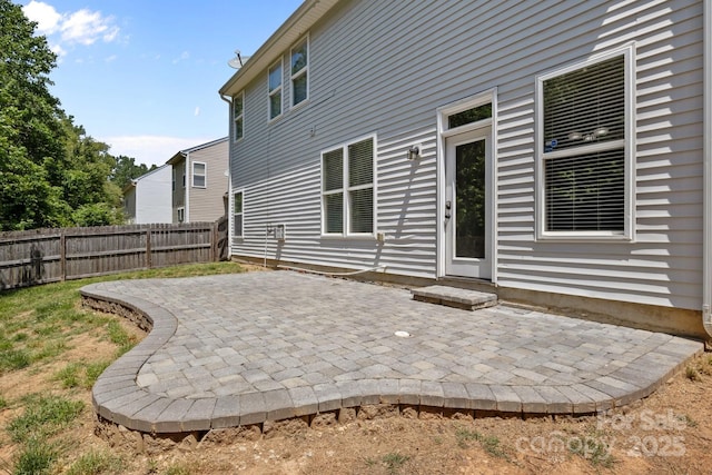 rear view of house featuring fence and a patio