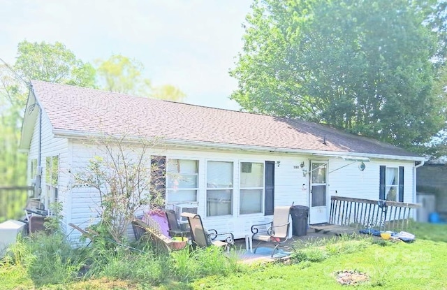 back of property featuring a shingled roof