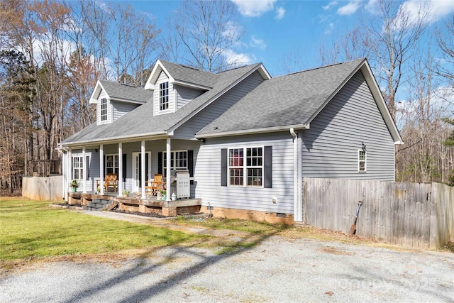cape cod home with fence, a shingled roof, a porch, a front yard, and crawl space