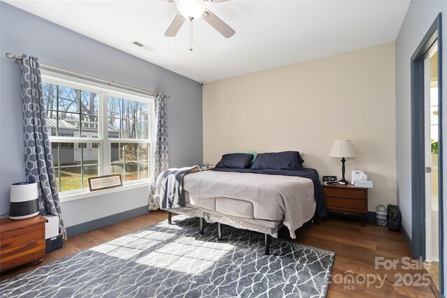 bedroom with ceiling fan, wood finished floors, and visible vents