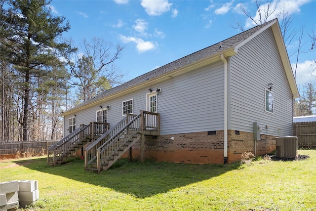 rear view of house featuring crawl space, a lawn, central air condition unit, fence, and stairs