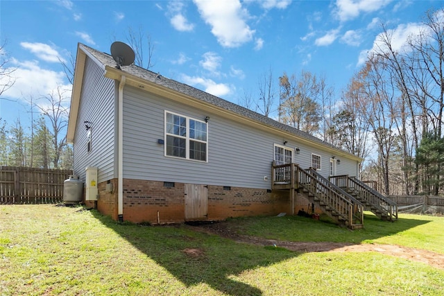 rear view of property with fence, stairs, a wooden deck, crawl space, and a lawn