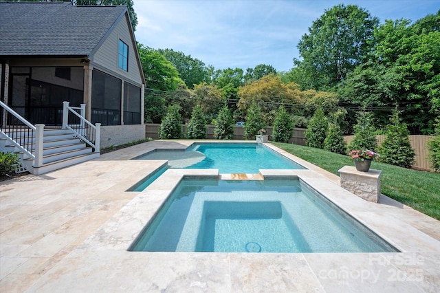 view of swimming pool featuring a patio, a pool with connected hot tub, a fenced backyard, and a sunroom