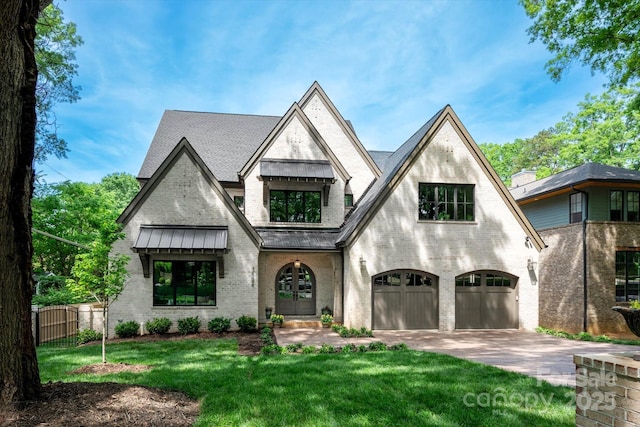 view of front of property with a standing seam roof, a front yard, a garage, brick siding, and fence