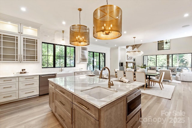 kitchen featuring a sink, appliances with stainless steel finishes, light wood-style floors, and open floor plan