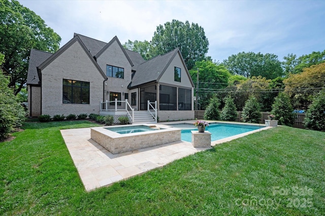 rear view of house with a sunroom, an in ground hot tub, a lawn, and an outdoor pool