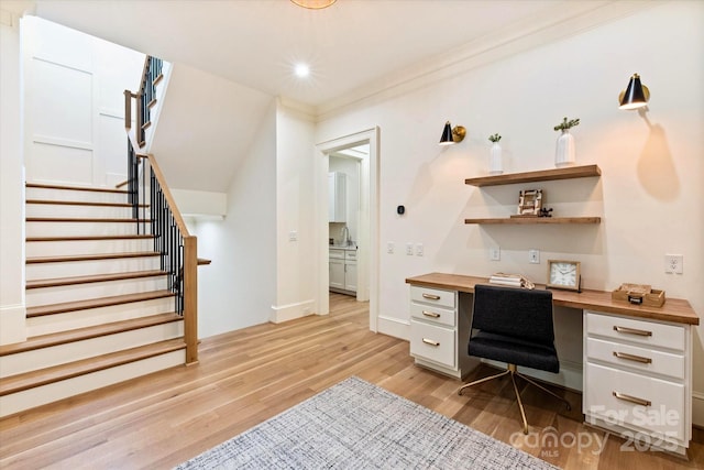 office area featuring built in study area, baseboards, recessed lighting, a sink, and light wood-style flooring