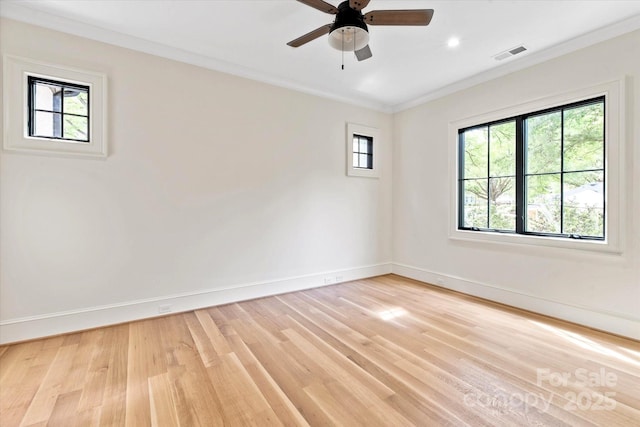 empty room with a healthy amount of sunlight, baseboards, light wood-type flooring, and visible vents