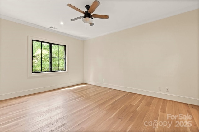 unfurnished room featuring light wood-style floors, a ceiling fan, baseboards, visible vents, and ornamental molding