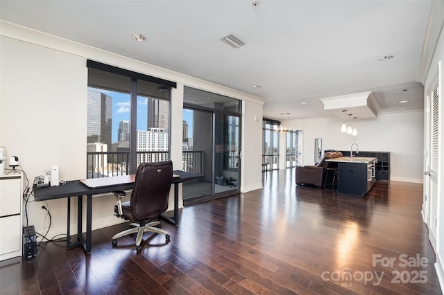 home office featuring a sink, ornamental molding, baseboards, visible vents, and dark wood-style floors