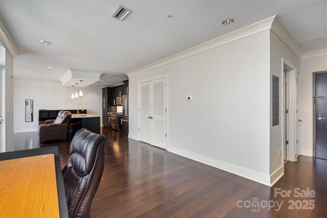 office featuring crown molding, baseboards, visible vents, and dark wood-type flooring