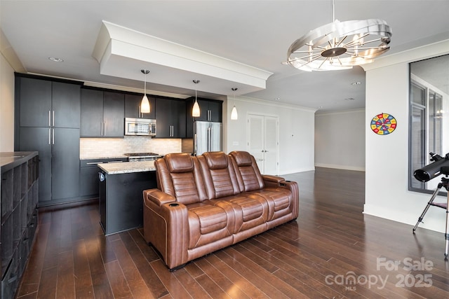 living room with dark wood-style flooring, baseboards, a chandelier, and ornamental molding