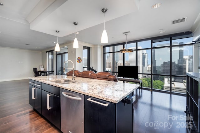 kitchen featuring a sink, dishwasher, dark cabinets, open floor plan, and dark wood-style floors
