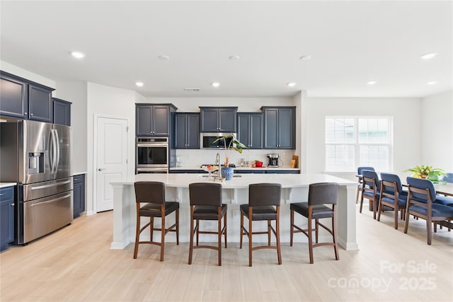 4069 Havenport Cir, Tega Cay, SC 29708 - kitchen featuring appliances with stainless steel finishes, light countertops, backsplash, an island with sink, and a kitchen breakfast bar