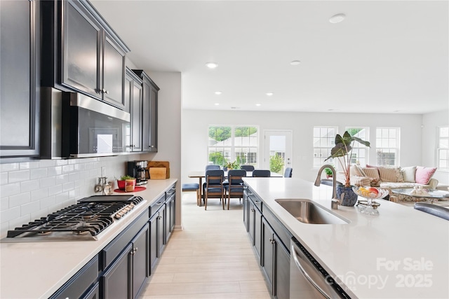 4069 Havenport Cir, Tega Cay, SC 29708 - kitchen with a sink, appliances with stainless steel finishes, light wood finished floors, light countertops, and open floor plan