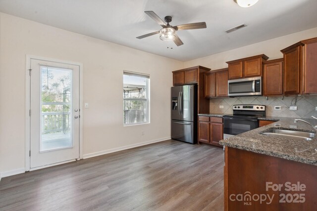 1175 Valley St Unit 111, Statesville, NC 28677 - kitchen with wood finished floors, a sink, dark stone counters, appliances with stainless steel finishes, and tasteful backsplash
