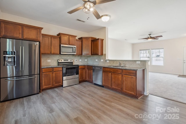 1175 Valley St Unit 111, Statesville, NC 28677 - kitchen with a ceiling fan, visible vents, a sink, brown cabinets, and stainless steel appliances
