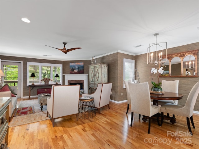 671 S Haywood St Unit 108B, Waynesville, NC 28786 - dining room with visible vents, a fireplace, baseboards, ceiling fan with notable chandelier, and light wood finished floors