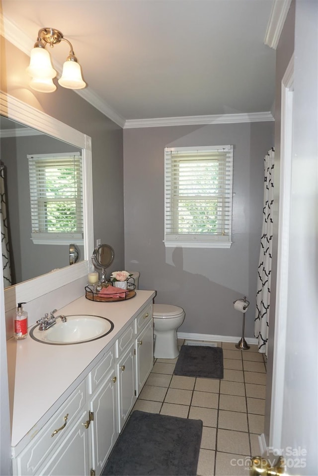 bathroom with plenty of natural light, ornamental molding, tile patterned flooring, and vanity