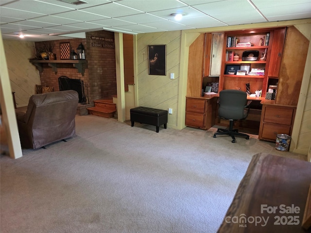 office featuring wood walls, light colored carpet, a paneled ceiling, and visible vents