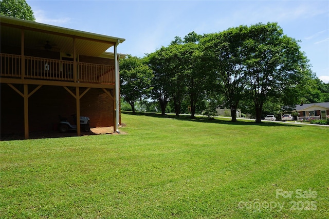 view of yard featuring ceiling fan and a deck