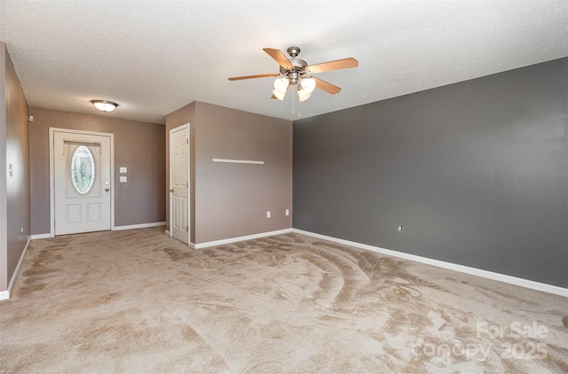 carpeted foyer entrance featuring baseboards, a textured ceiling, and ceiling fan
