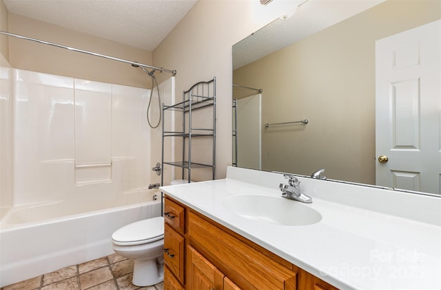 bathroom featuring stone finish flooring, a textured ceiling, vanity, toilet, and  shower combination