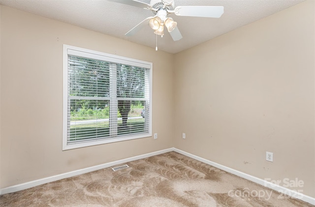 spare room with baseboards, visible vents, and carpet