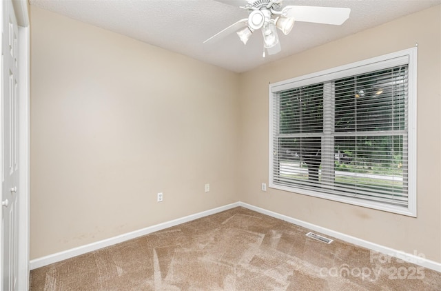 carpeted empty room with a ceiling fan, baseboards, and visible vents