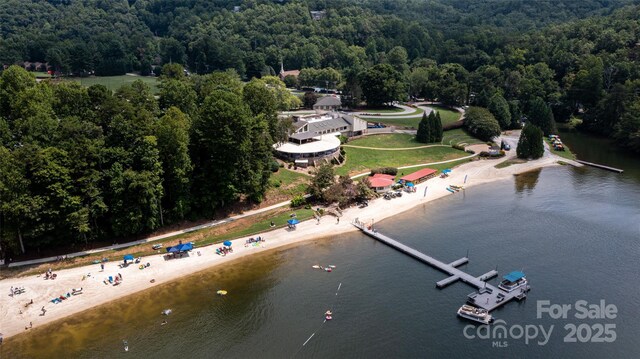 drone / aerial view of a heavily wooded area and a large body of water