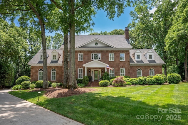 12048 Royal Portrush Dr, Charlotte, NC 28277 - colonial-style house featuring brick siding, a chimney, and a front lawn