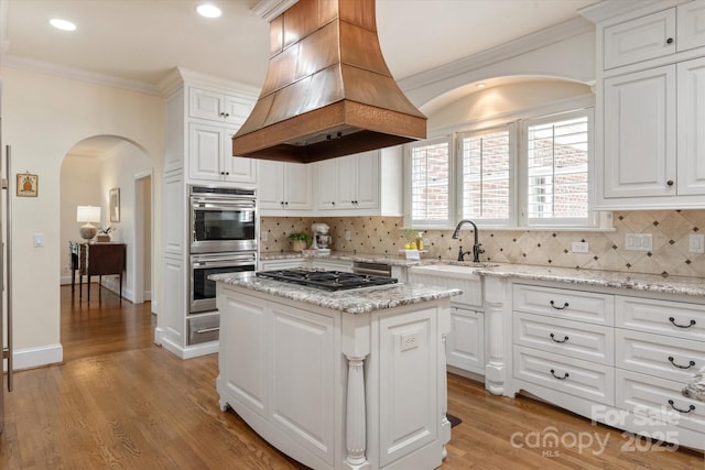 12048 Royal Portrush Dr, Charlotte, NC 28277 - kitchen with crown molding, island range hood, arched walkways, a sink, and appliances with stainless steel finishes