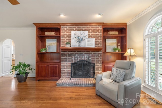 12048 Royal Portrush Dr, Charlotte, NC 28277 - living room with arched walkways, ornamental molding, wood finished floors, and a fireplace