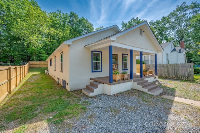 bungalow-style home featuring a porch, fence private yard, and stucco siding