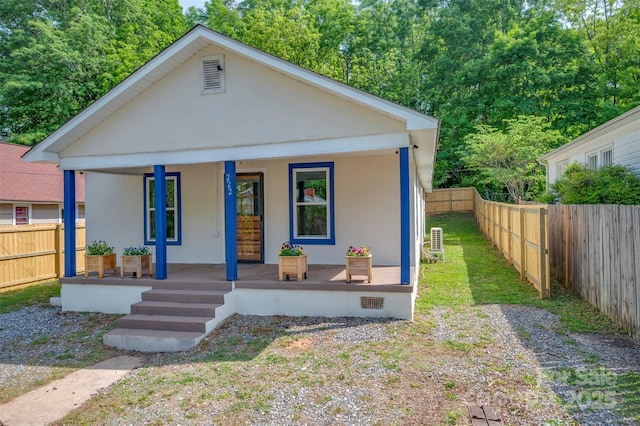 bungalow-style home featuring a fenced backyard, stucco siding, and a porch
