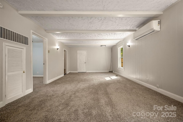 unfurnished room with beam ceiling, baseboards, a wall mounted air conditioner, a textured ceiling, and carpet