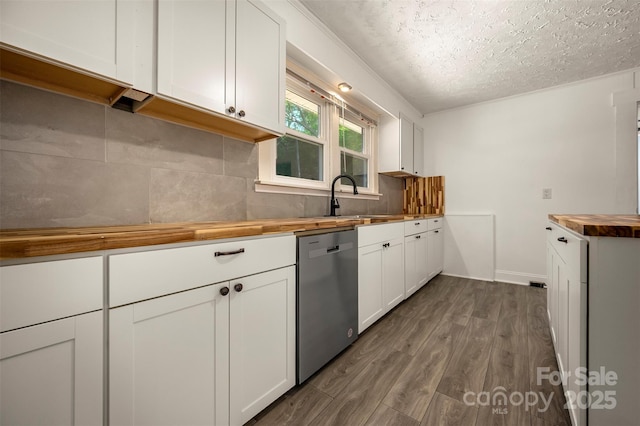 kitchen featuring wooden counters, a textured ceiling, dishwasher, a sink, and white cabinetry