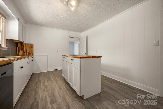 kitchen featuring butcher block countertops, a textured ceiling, stainless steel dishwasher, white cabinetry, and dark wood-type flooring
