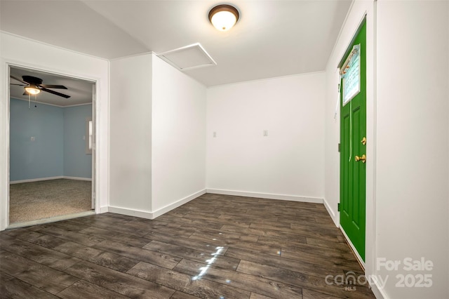 unfurnished room featuring baseboards, attic access, and dark wood-type flooring