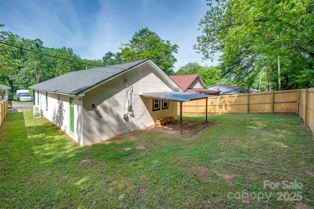 back of property with a lawn, a fenced backyard, and stucco siding