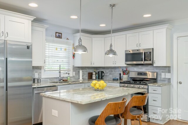 4838 Holbrook Dr, Charlotte, NC 28212 - kitchen with stainless steel appliances, a sink, a kitchen bar, white cabinetry, and recessed lighting
