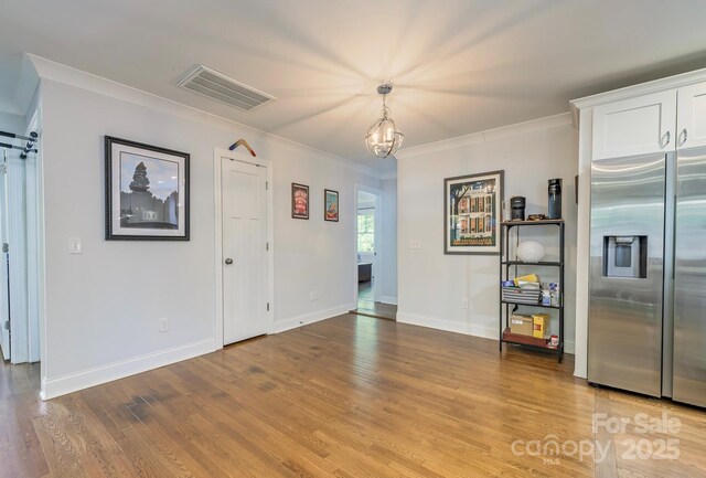 4838 Holbrook Dr, Charlotte, NC 28212 - unfurnished dining area with wood finished floors, ornamental molding, baseboards, and a chandelier