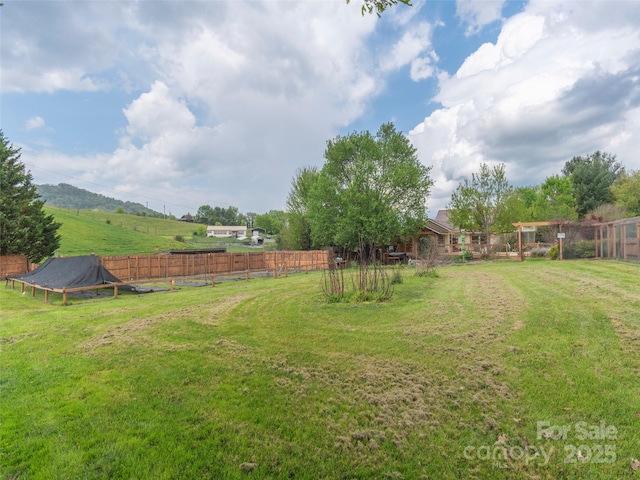 view of yard featuring fence and a rural view