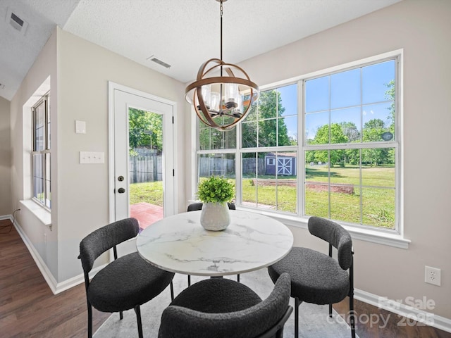 4101 New Castle Ln, Monroe, NC 28110 - dining room featuring a chandelier, dark wood-type flooring, baseboards, and a textured ceiling