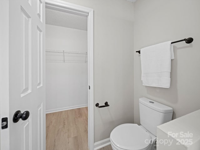 4101 New Castle Ln, Monroe, NC 28110 - bathroom with wood finished floors, toilet, baseboards, and a textured ceiling