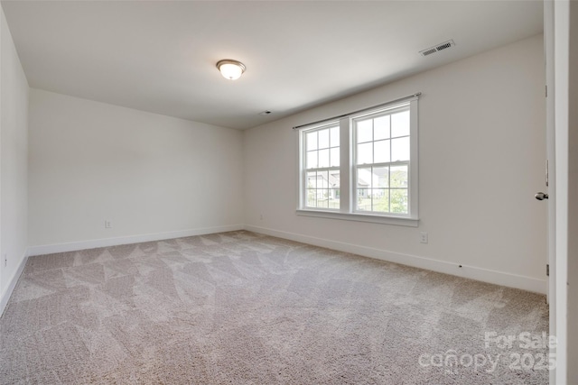 unfurnished room with visible vents, baseboards, and light carpet