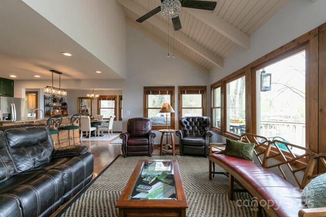 living area featuring a chandelier, a ceiling fan, beamed ceiling, recessed lighting, and wood finished floors