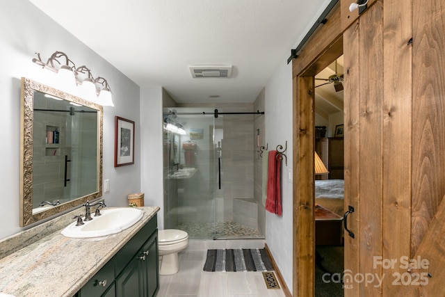 bathroom with a shower stall, toilet, and vanity